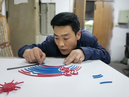5.维修工用废旧电线拼接出亚运会徽3